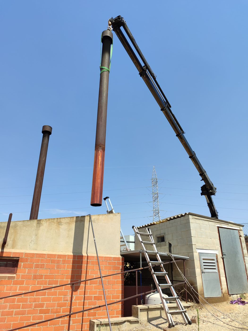 Montaje con grúa de la chimenea de una sala de calderas